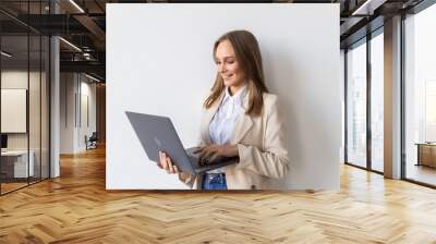 Portrait of young businesswoman holding laptop in the office isolated over white background Wall mural